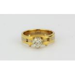 An 18ct yellow and white gold (stamped 18ct) solitaire ring set with an 0.65ct brilliant cut