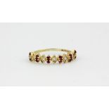 A 9ct yellow gold ruby and diamond set half eternity ring, (O.5).