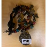 An interesting Tibetan necklace of sacred and memorable objects collected on a pilgrimage, folded L.