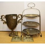 A silver plated cake stand, a heavy brass urn and a pair of candle sticks.