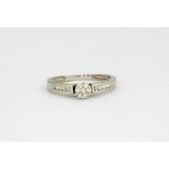 A 9ct white gold diamond set cluster ring with diamond set shoulders, approx. 1.7gr, (M).