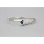 A lovely 14ct white gold bangle set with a triangular cut tanzanite. Internal width 5.9cms.