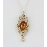 A yellow metal (tested 9ct gold) amber pendant and chain, L. 5cm.