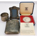 A silver cigarette case, napkin ring, small photograph frame and a cased silver proof Jubilee