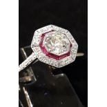 An 18ct white gold ring set with a brilliant cut diamond centre stone surrounded by rubies and