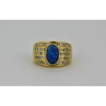 An impressive and heavy quality 18ct yellow gold ring set with a deep blue doublet opal and five