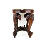 An early 20th Century Burmese carved teak table with Elephant heads as legs, H. 47cm. W. 39cm.