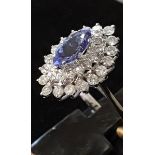 An 18ct white gold cluster ring set with a marquise cut tanzanite surrounded by brilliant cut