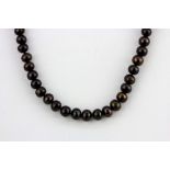 A single strand necklace of chocolate brown cultured pearls (7.5mm), L. 42cm adjustable.