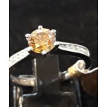 An 18ct white gold solitaire ring set with a brilliant cut fancy brownish yellow diamond and diamond