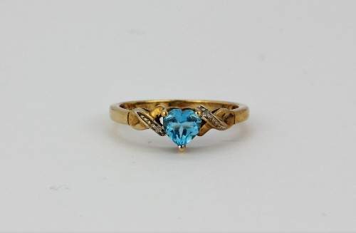 A 9ct yellow gold ring set with a heart cut blue topaz and diamond set shoulders, (K.5).