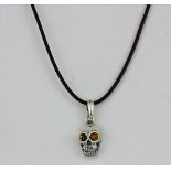 A 925 silver amber set skull shaped pendant and matching pair of earrings, L. 2.5cm.
