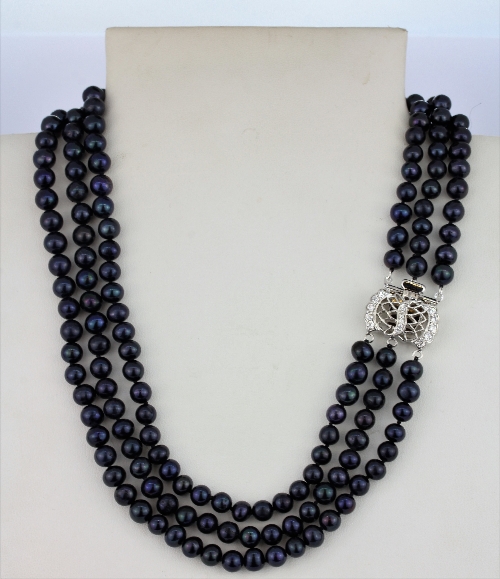 A triple row blue /black cultured pearl necklace on a stone set white metal clasp, L. 44cm, together - Image 2 of 3