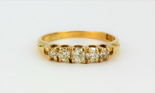 An 18ct yellow gold ring set with five graduated old cut diamonds, (P.5).
