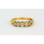 An 18ct yellow gold ring set with five graduated old cut diamonds, (P.5).