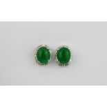 A pair of 18ct white gold plate mounted oval jade earrings surrounded by baguette cut white