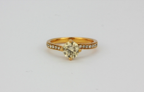 An 18ct rose gold solitaire ring set with a 1ct brilliant cut diamond and diamond set shoulders, (