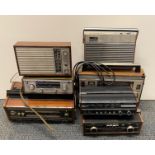 Seven wooden cased portable radios.