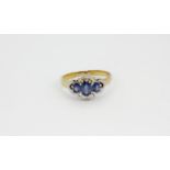 A 9ct yellow gold ring set with oval cut sapphires surrounded by brilliant cut diamonds, (P.5).