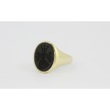 A gentleman's yellow metal (tested high carat gold) signet ring set with a carved hematite,