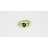 An 18ct yellow gold ring set with an oval cut emerald and brilliant cut diamonds, (L.5).