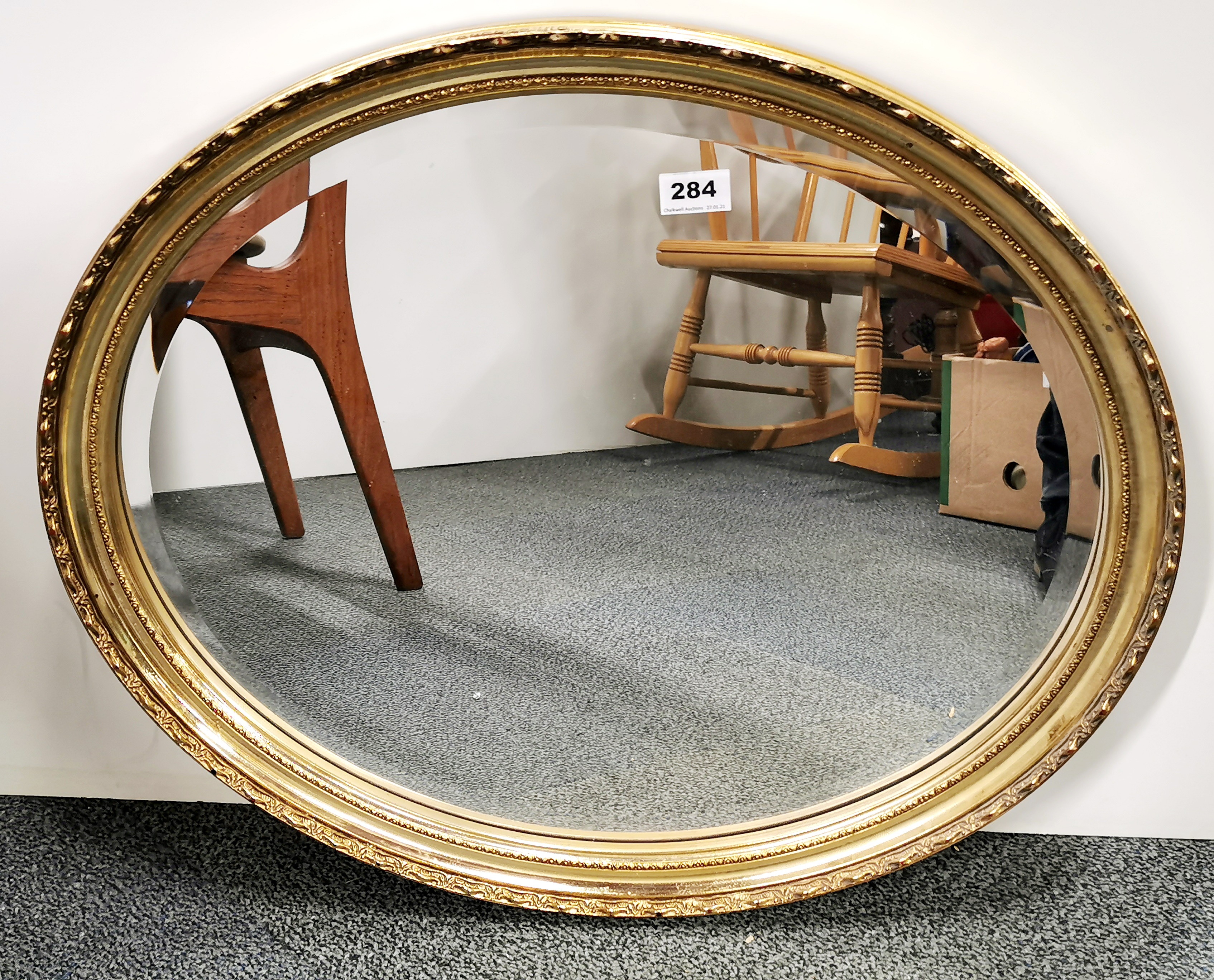 A gilt framed oval mirror, 66cm x 57cm.