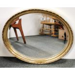 A gilt framed oval mirror, 66cm x 57cm.