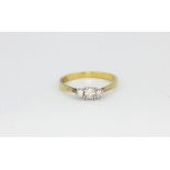 An 18ct yellow and white gold trilogy ring set with graduated brilliant cut diamonds, (P.5).