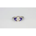 An 18ct white gold ring set with a fancy cut diamond and trillion cut tanzanites, approx. 1.09ct