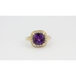 A 9ct yellow gold ring set with an amethyst surrounded by diamonds, (K).