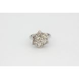 An 18ct white gold (stamped 750) cluster ring set with brilliant cut diamonds, approx. 3.15ct, (I).