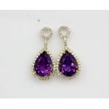 A pair of 18ct yellow gold (stamped 750) drop earrings set with large pear cut amethysts and