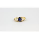 An antique yellow metal (tested 18ct gold) ring set with an oval cut sapphire and old cut