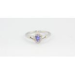 A 9ct white gold pear cut tanzanite and diamond set cluster ring, (O).