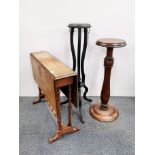 A 19th century walnut veneered Pembroke table and two plant stands.