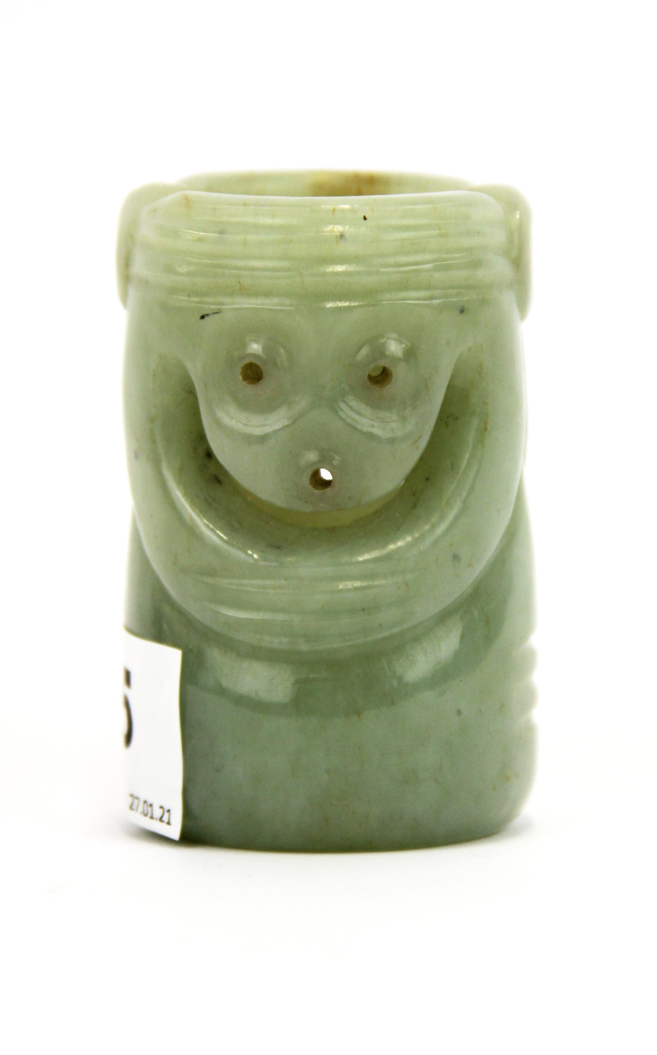 An unusual Chinese carved pale celadon russet jade cylinder decorated with two mask like faces, H.