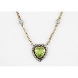 A French yellow metal (tested minimum 9ct gold) necklace set with a heart cut peridot surrounded