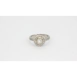 An 18ct white gold halo ring set with a brilliant cut centre diamond surrounded by brilliant cut