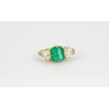 A yellow metal (tested 18ct gold) ring set with a Columbian emerald flanked by old and rose cut
