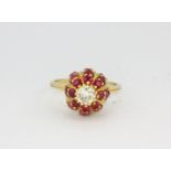 An 18ct yellow gold (stamped 18ct) cluster ring set with rubies and a large brilliant cut diamond,