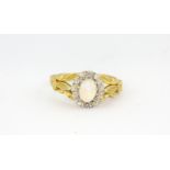An 18ct yellow gold opal and diamond set cluster ring, (M).