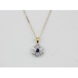 An 18ct yellow and white gold diamond and sapphire set daisy cluster pendant on a 9ct yellow gold