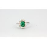 An 18ct white gold (stamped 750) ring set with an emerald cut emerald and brilliant cut diamonds,