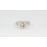 A 9ct white gold diamond set cluster ring with diamond set shoulders, (K).