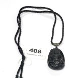 A lovely carved obsidian amulet of a seated Buddha, H. 6cm