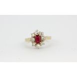 An 18ct yellow gold (stamped 18k) cluster ring set with an emerald cut ruby surrounded by old cut