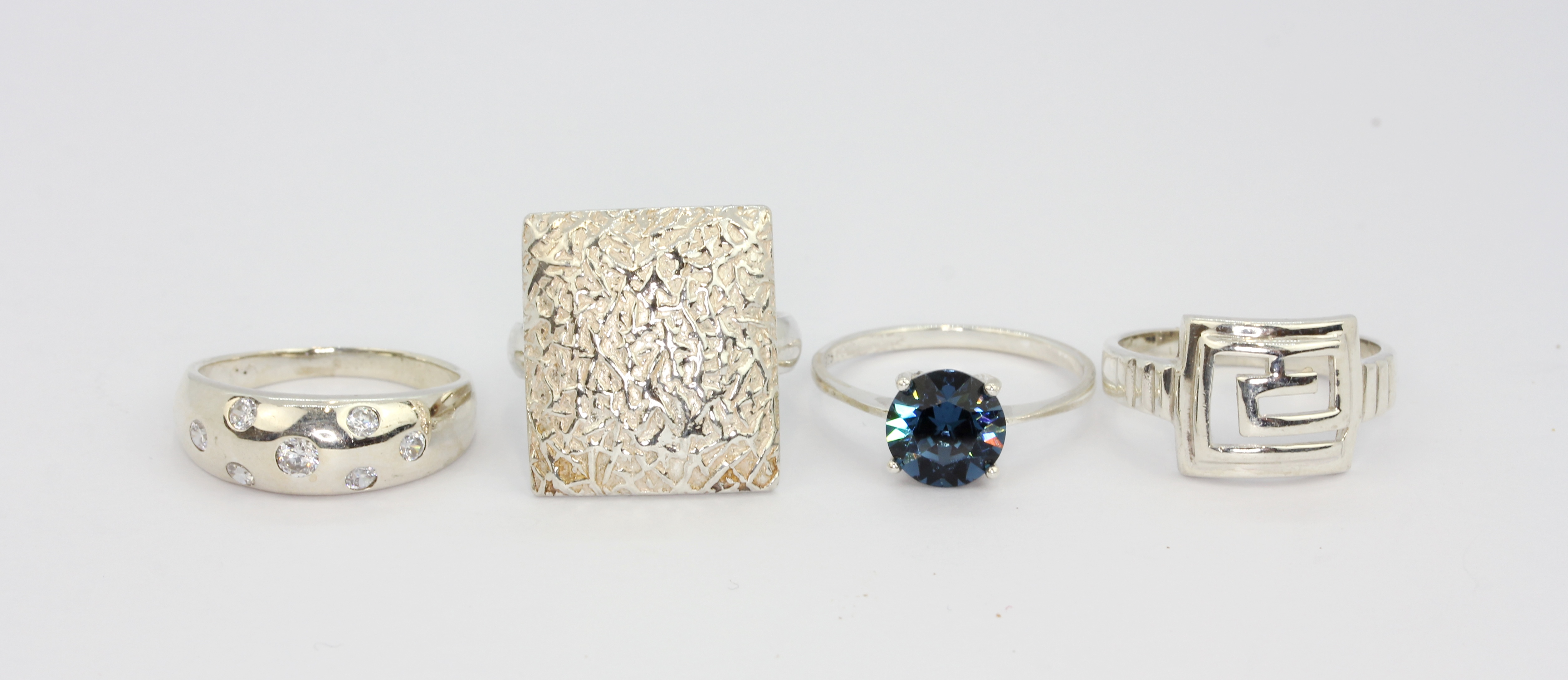 Four 925 silver stone set rings.