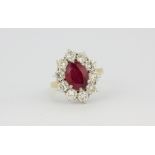 An 18ct yellow gold cluster ring set with an oval cut ruby surrounded by brilliant cut diamonds,