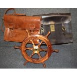 Two vintage leather attache cases and a wooden ships wheel.