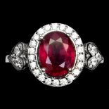 A 925 silver cluster ring set with an oval cut ruby surrounded by white stones, (O).